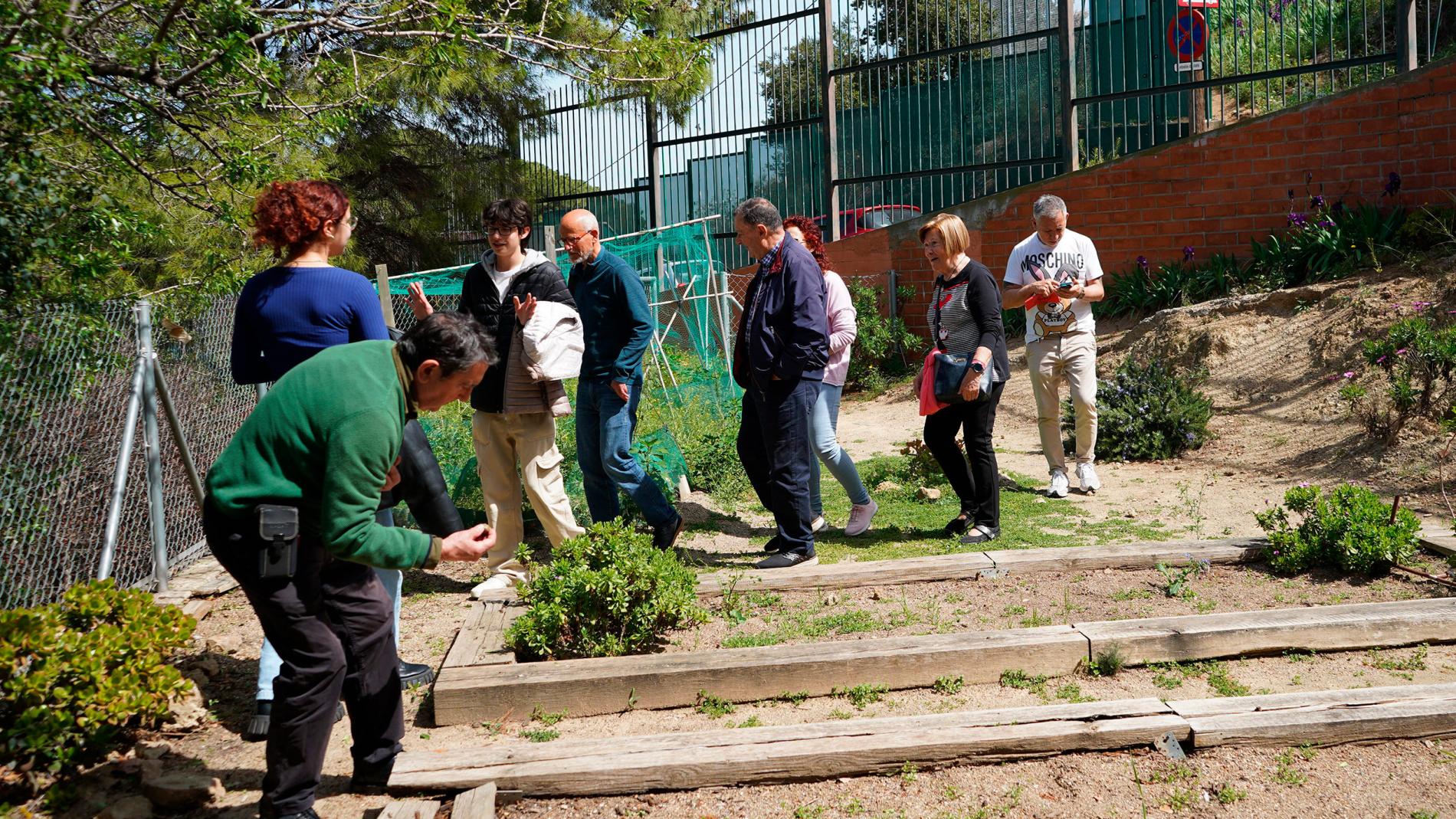 Pacients amb Parkinson i alumnes de 4t d'ESO visitant l'hort de l'Institut Coves d'en Cimany