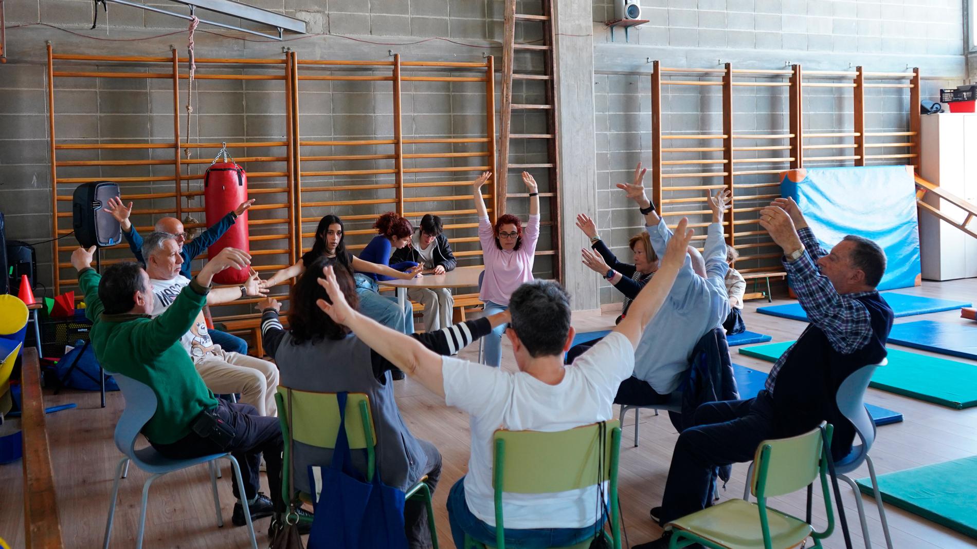 Pacients amb Parkinson i alumnes de 4t d'ESO fent ioga