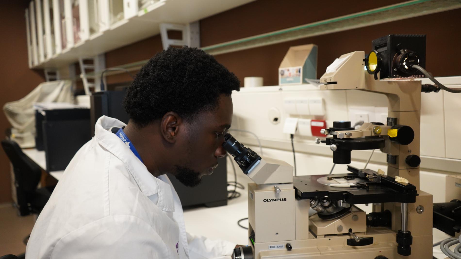Freddy Ganse looking through the microscope